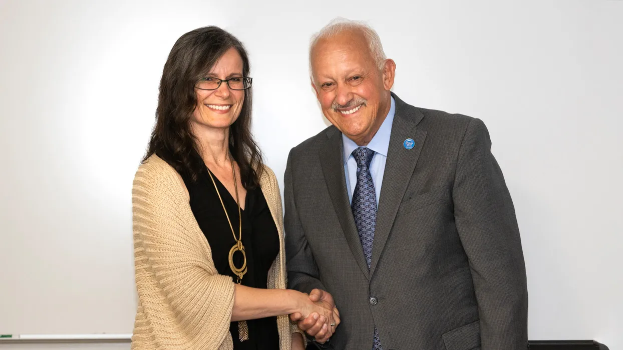 CSUSB President Tomás D. Morales congratulates Gisela Bichler, professor of criminal justice, on being honored with CSUSB’s 2023-2024 Outstanding Professor Award.