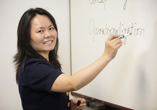 Faculty writing on white board