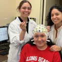 Honor student Camryn Amundsen and Master’s student Melissa Lopez prepare a participant for EEG data acquisition.