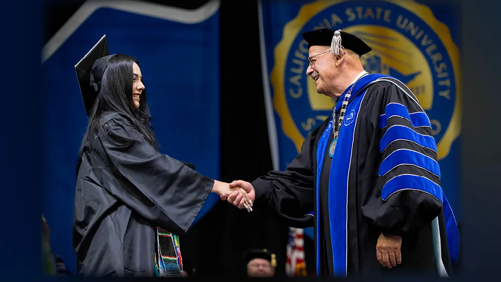 CSUSB President Tomás D. Morales congratulates a member of the Class of 2024 at the College of Social and Behavioral Sciences Commencement ceremony on May 17.