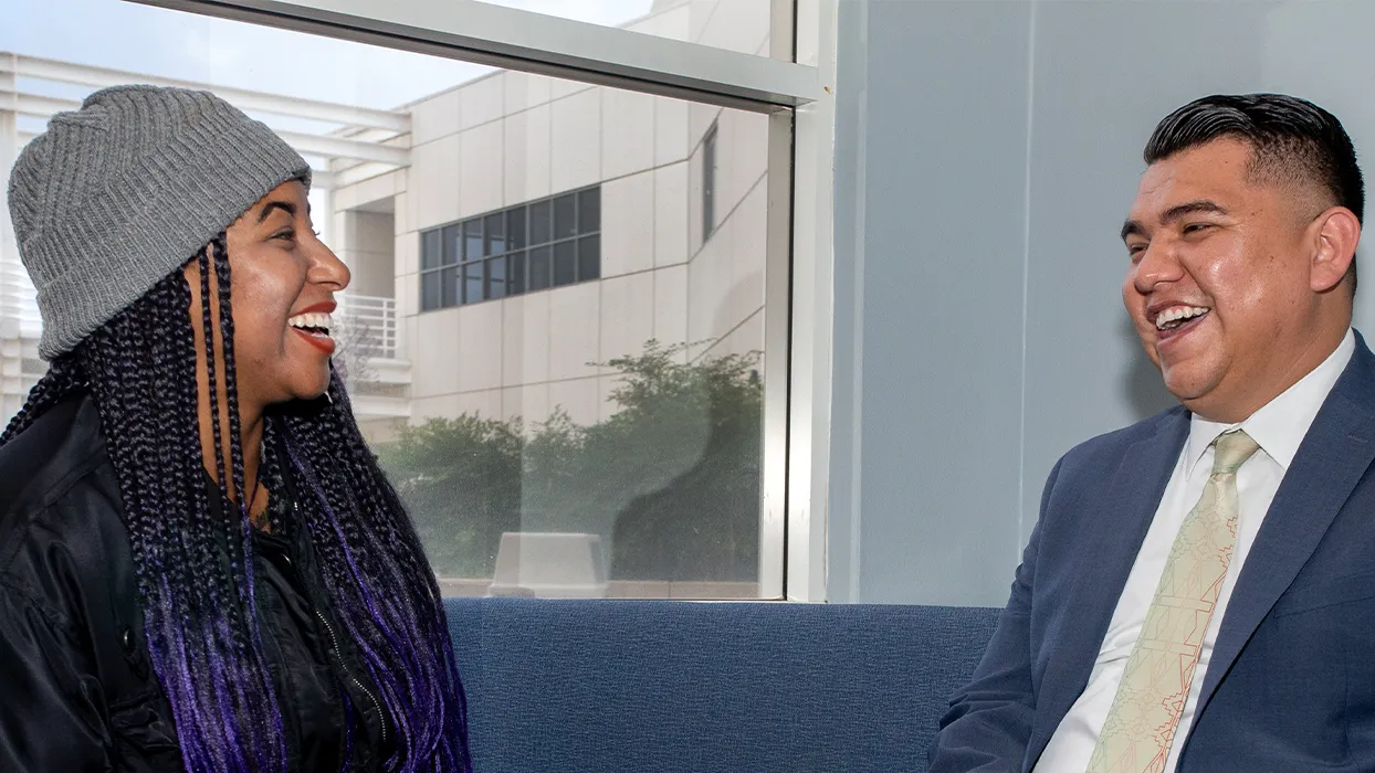 CSUSB student Asia Ponder (left) talks with alumnus Alberto Jasso ’15 about her courses.