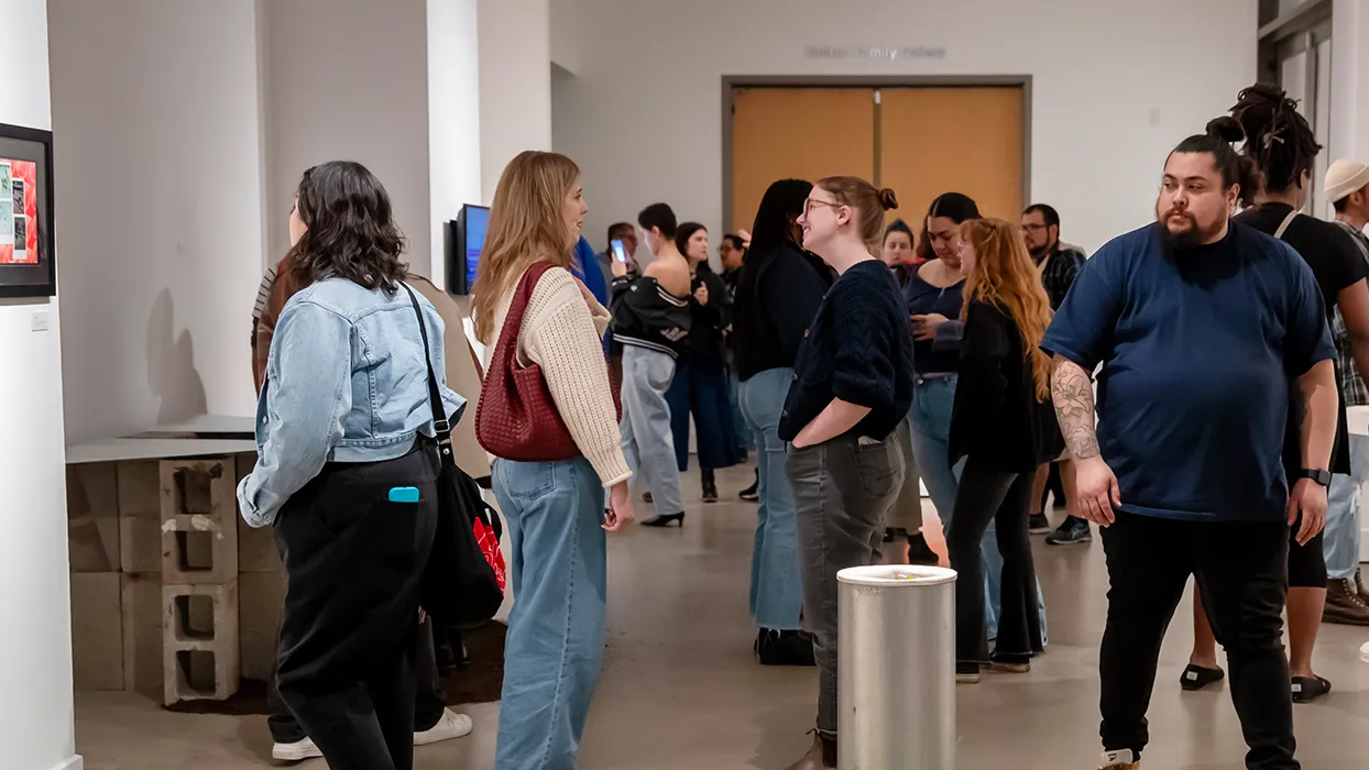 Attendees study the artwork displayed at the Feb. 8 reception for the “Echoes of Identity” exhibit at the Robert and Frances Fullerton Museum of Art.