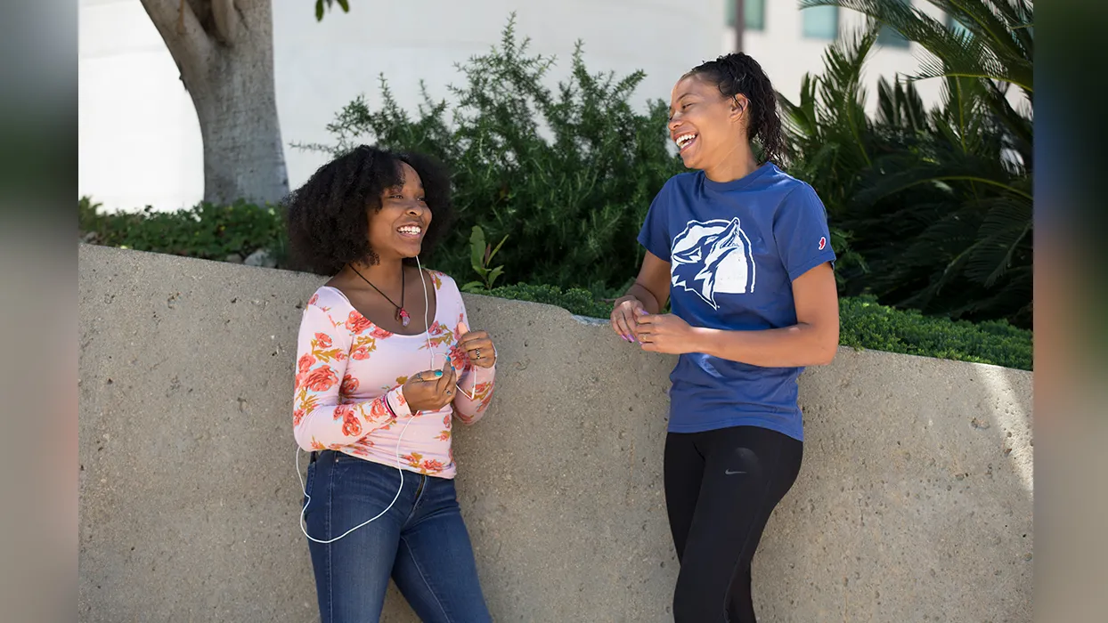 Two African American women laughing on the CSUSB campus.