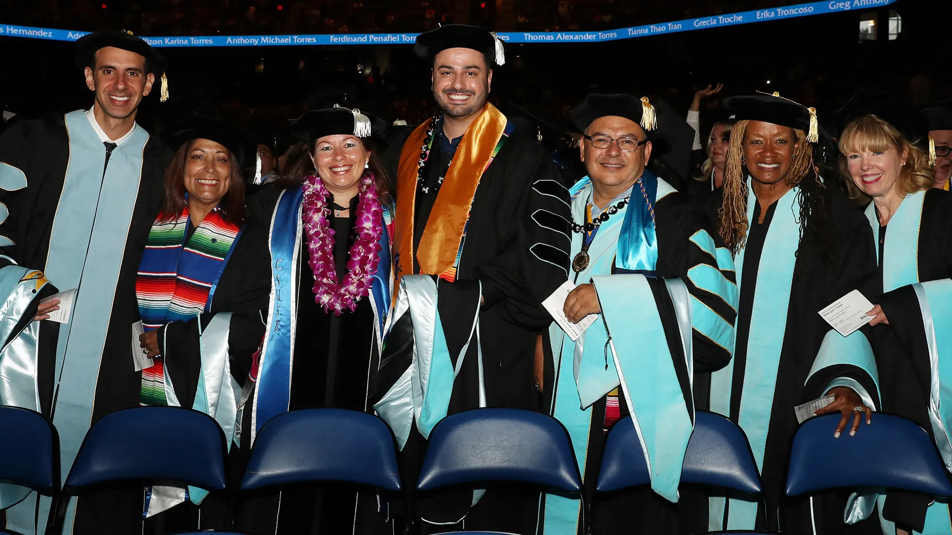 CSUSB graduates smiling at the 2019 commencement at the Toyota Arena