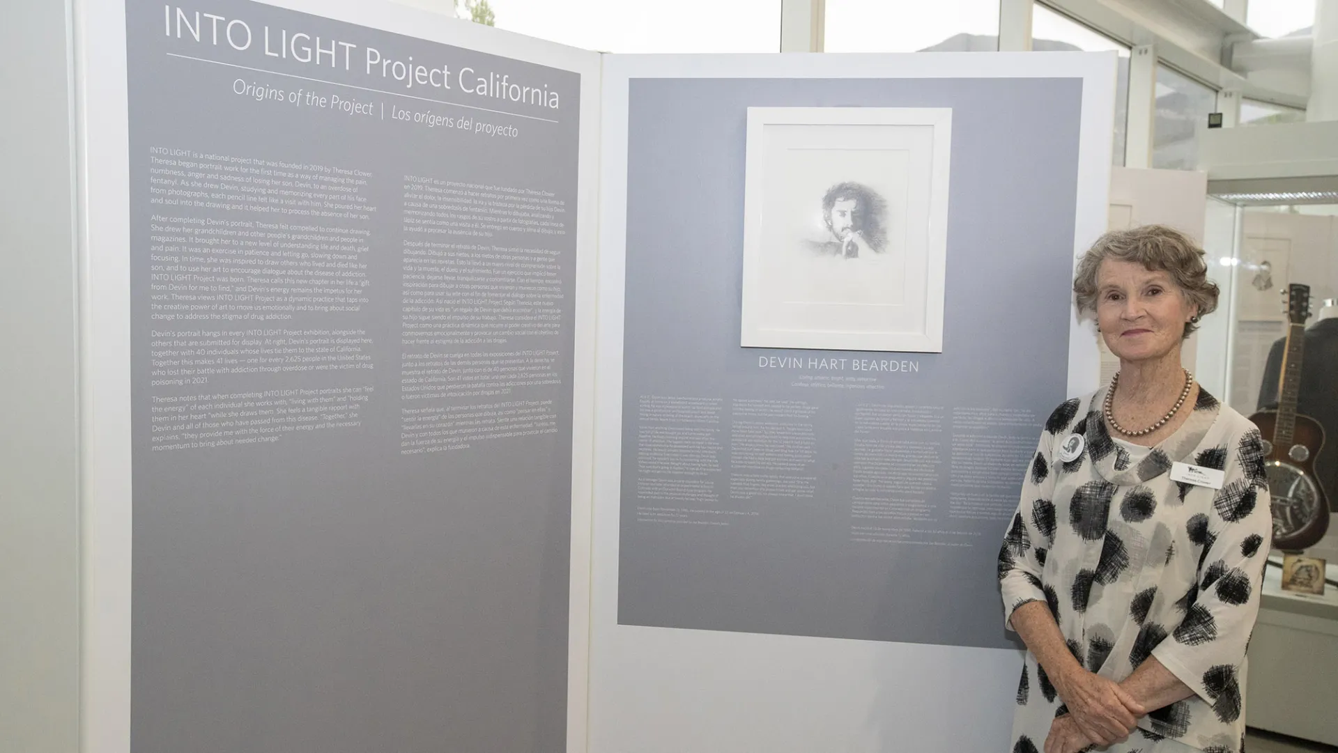 Theresa Clower, standing by her portrait of her son, Devin, started the INTO LIGHT Project. After completing Devin’s portrait, she was inspired to find others who lived and died like her son and to show the extent of the drug epidemic through exhibits involving each state.