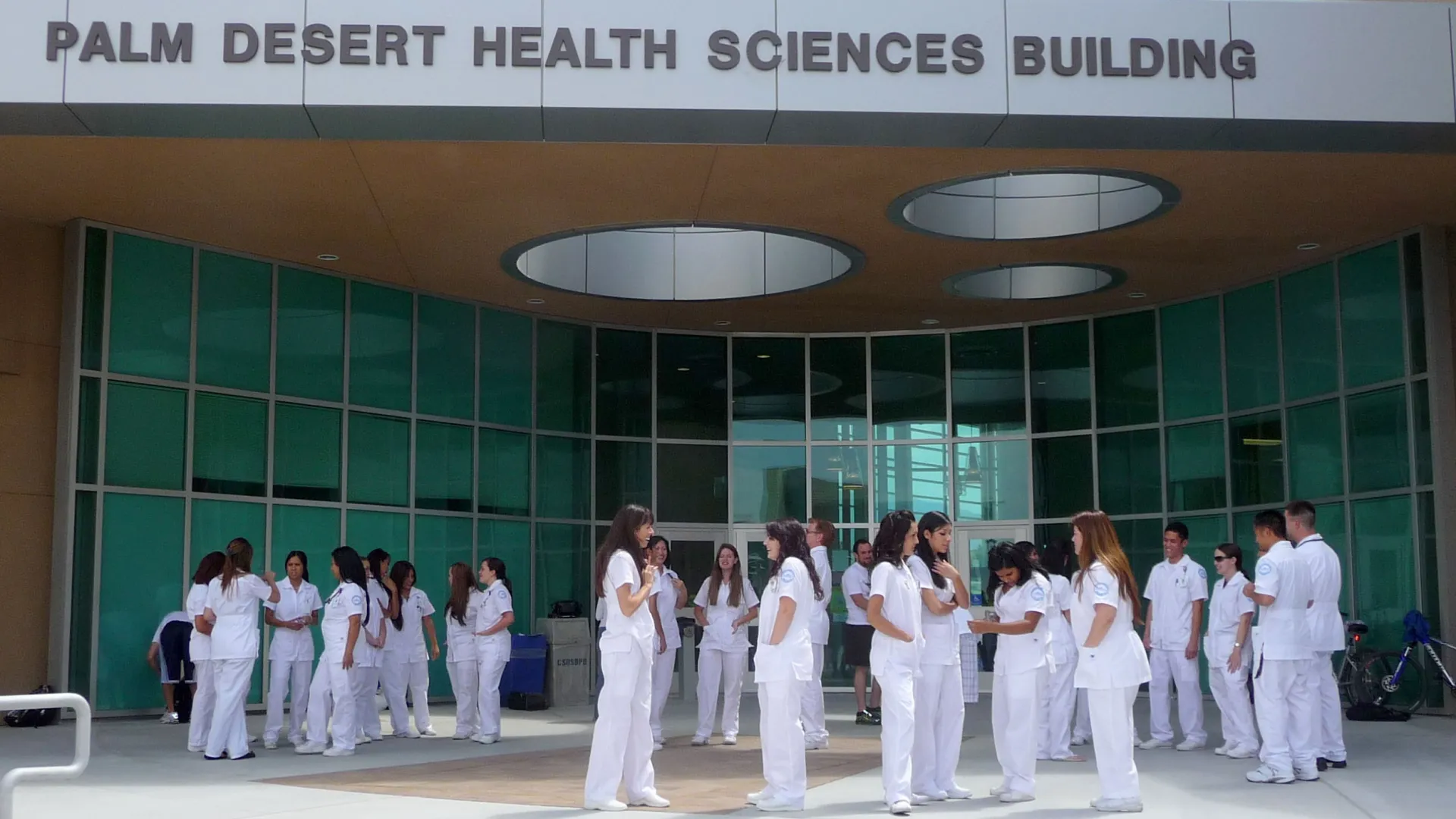 Nursing students gather in front of the Palm Desert Health Sciences Building at the Palm Desert Campus