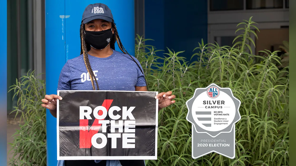 CSUSB student holding the Rock the vote sign