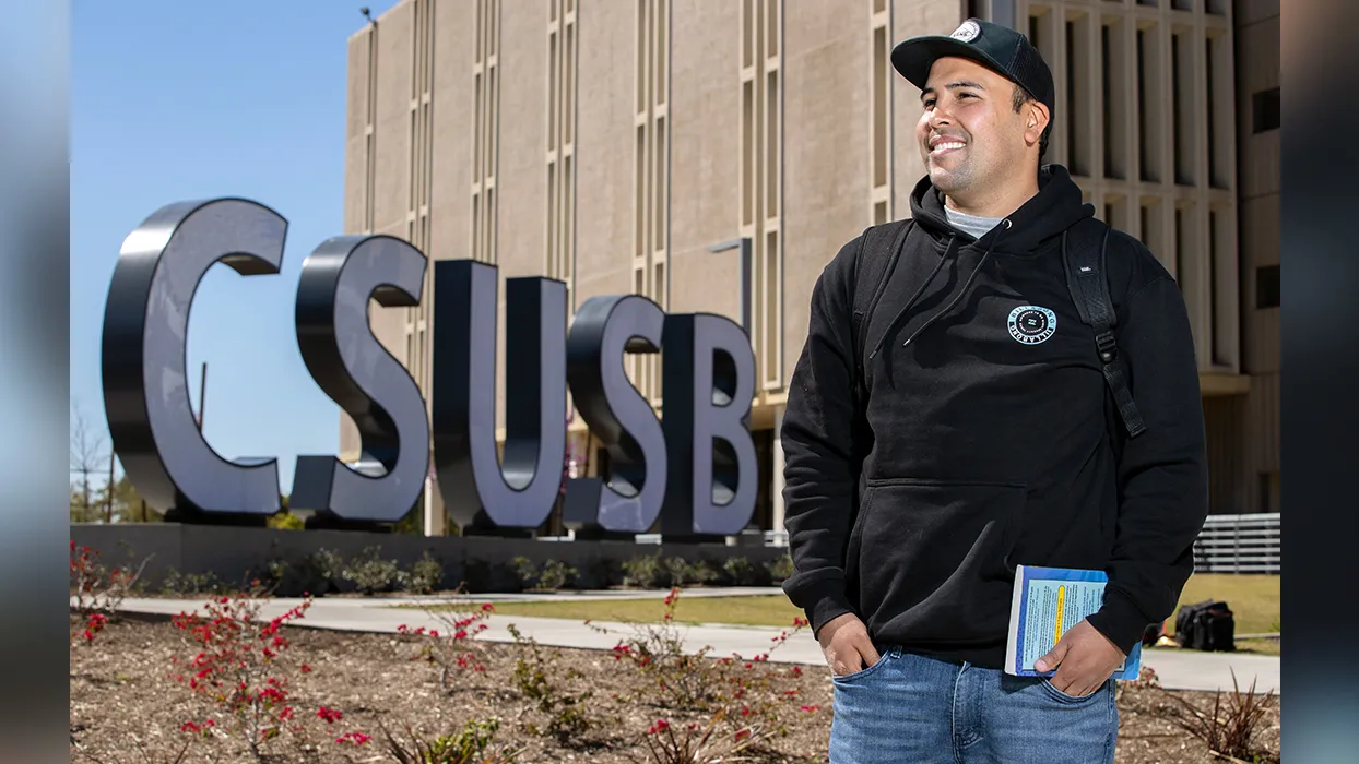 Student by the CSUSB monument sign