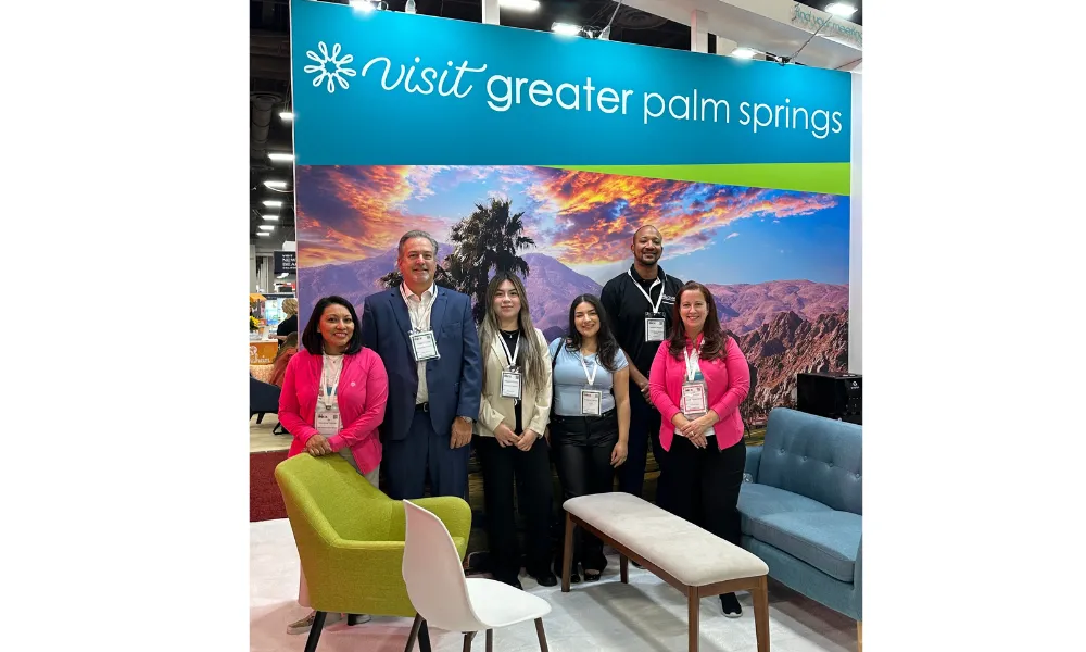 6 individuals standing next to a VISIT GREATER PALM SPRINGS sign