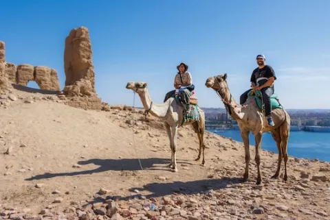 2 students sit on camels in Egypt