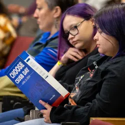 Two people looking over the Choose CSUSB Day program.