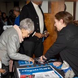 Lucia Zarate (right), of CSUSB’s Outreach and Student Recruitment team, shares information on the university with a member of St. Paul AME Church at the 2024 Super Sunday outreach.
