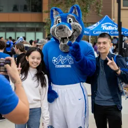 Cody Coyote poses for a picture with a couple of attendees from last year’s Homecoming Bash.