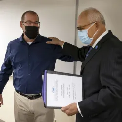 Mark Agars (left) reacts as university President Tomás D. Morales announces that Agars is the recipient of the 2021-22 Outstanding Professor award.