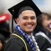 CSUSB graduate smiles in cap and gown.