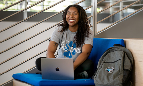 Student smiling while on her laptop