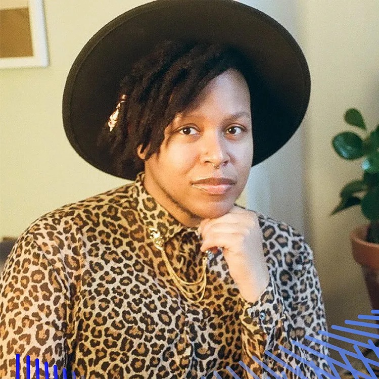 Cyrée Jarelle Johnson, African American wispy beard, broad-brimmed black hat, leopard-print shirt, hand on chin