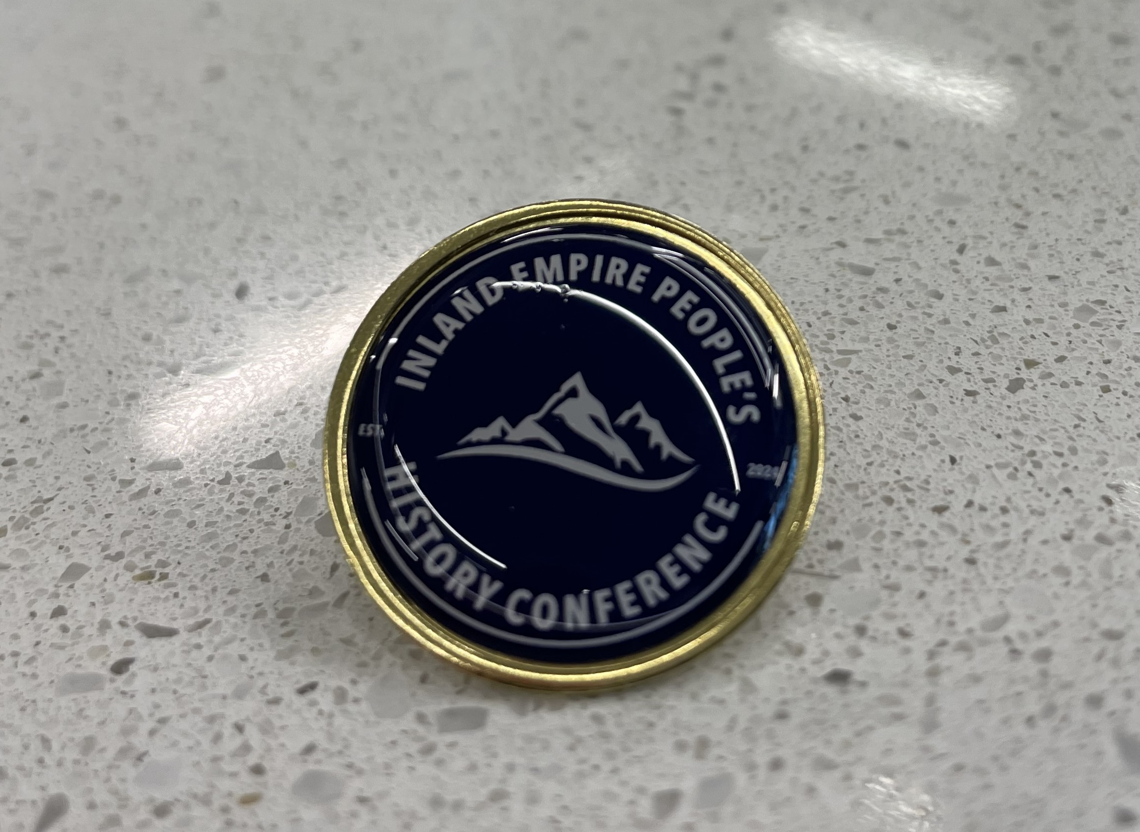 A commemorative pin received by all attendees of the inaugural “Inland Empire People’s History Conference” held on June 1, 2024.
