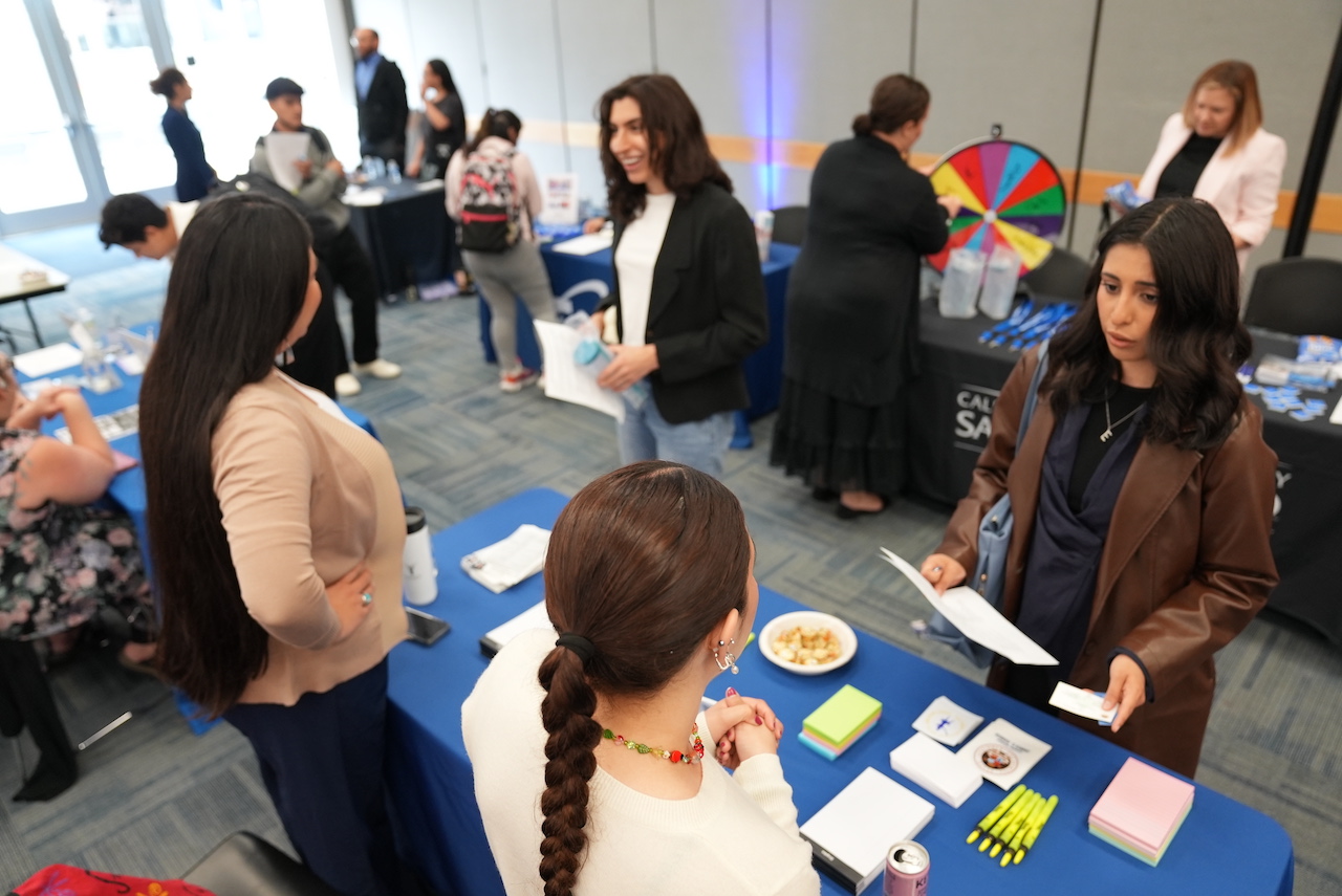 Job seekers and recruiters mingling at a job fair inside an office building.