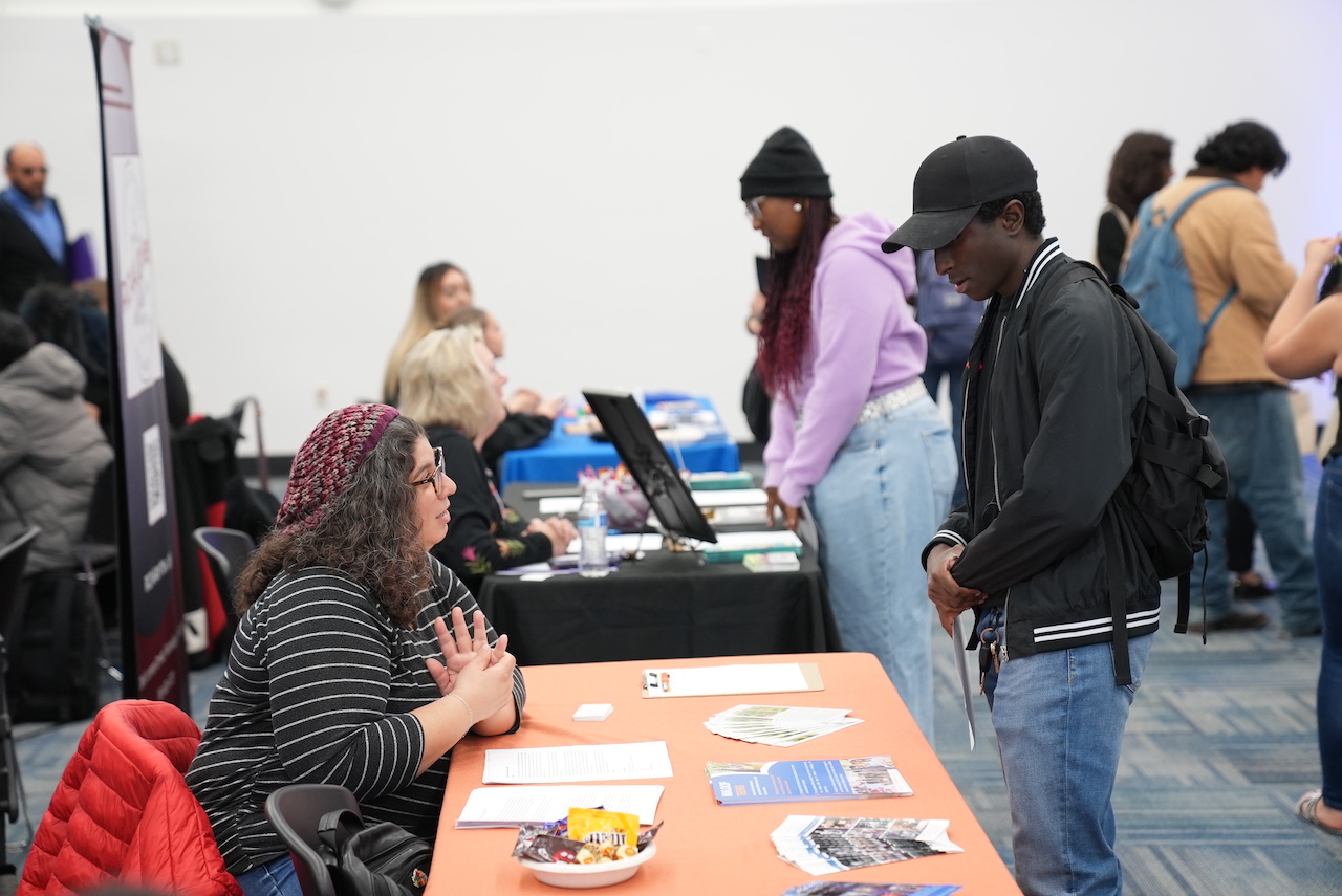 Crowd of people exploring career opportunities at an indoor job fair event.