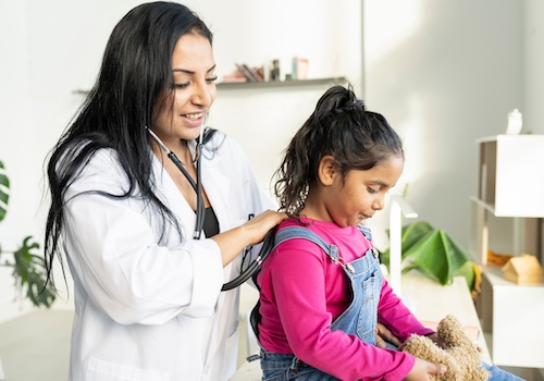 Doctor checking child's breathing with a stethoscope