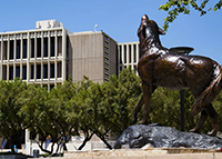 The Wild Song statue on the CSUSB campus with the John M. Pfau Library in the background.