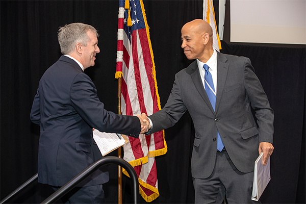 Dr. Tony Coulson (left) shakes hands with White House Deputy National Cyber Director Harry Wingo.