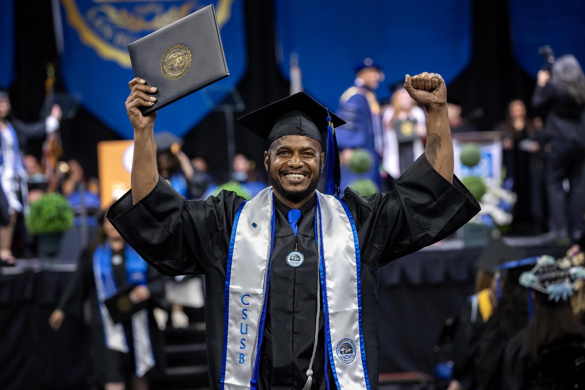 A male graduate celebrates at the CSBS Commencement ceremony on May 17