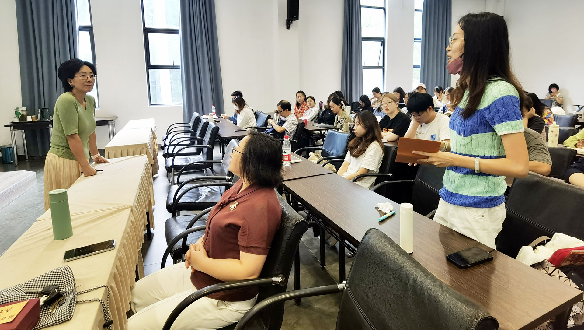 Yawen Li, CSUSB professor of social work (at far left) who presented a talk at Yunnan University, interacts with a member of the audience at the July 10 program.