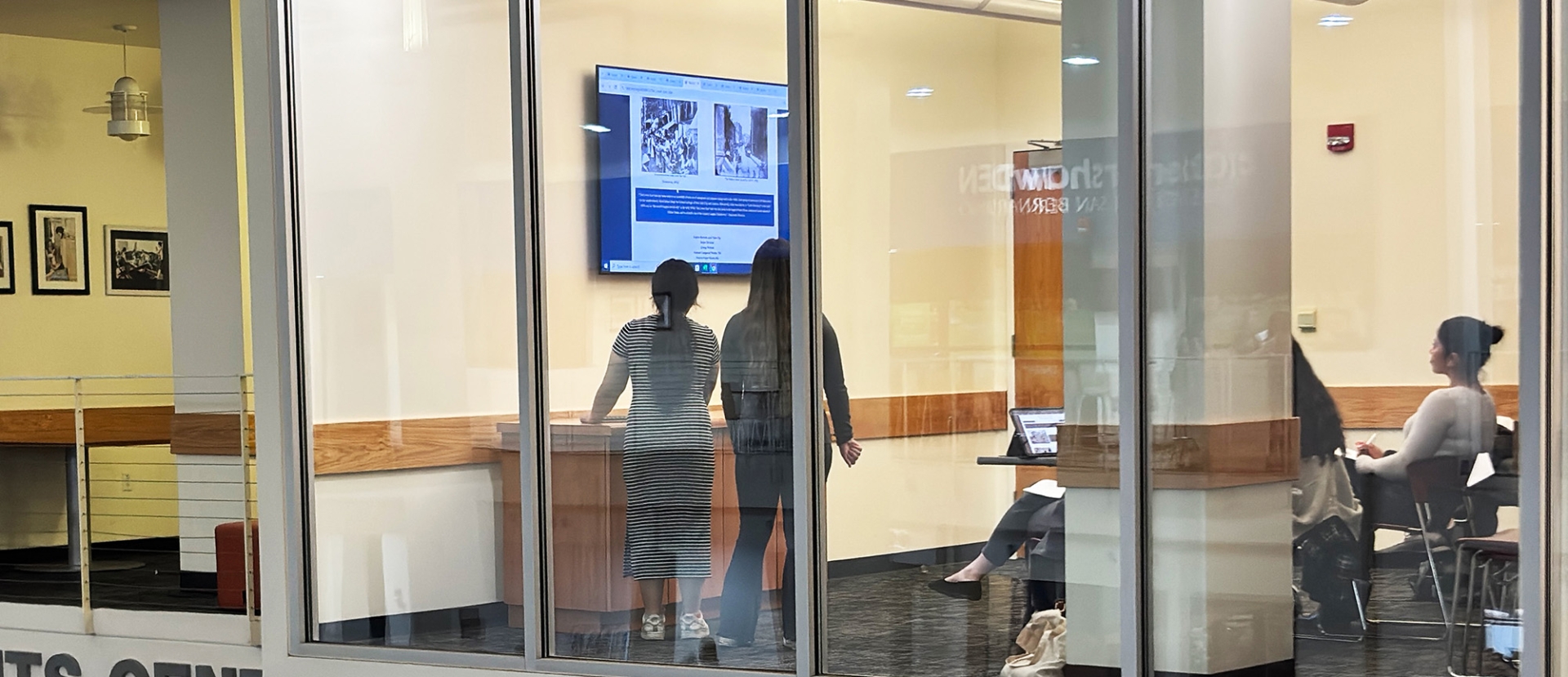 Two students present their History Day project on a video monitor in one of the skyboxes at Cal State San Bernardino’s Santos Manuel Student Union-South.