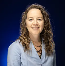 Jessica Luck in front of a blue background.