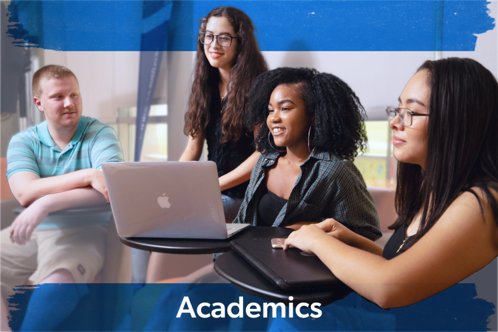 A diverse group of four students engaged in a study session. They are gathered around a laptop, smiling and focused. Text reads "Academics."