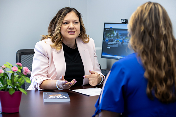 Maggie Boyraz, associate professor of management, speaking with a student.