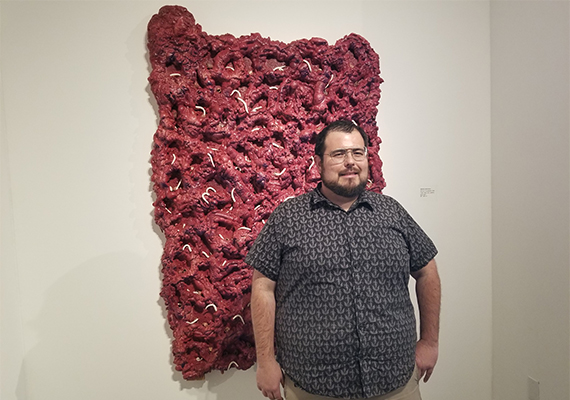 Matthew Dickerson, MFA student and ceramic lab technician for art and design, with his piece, “Barbaric Concessions.”