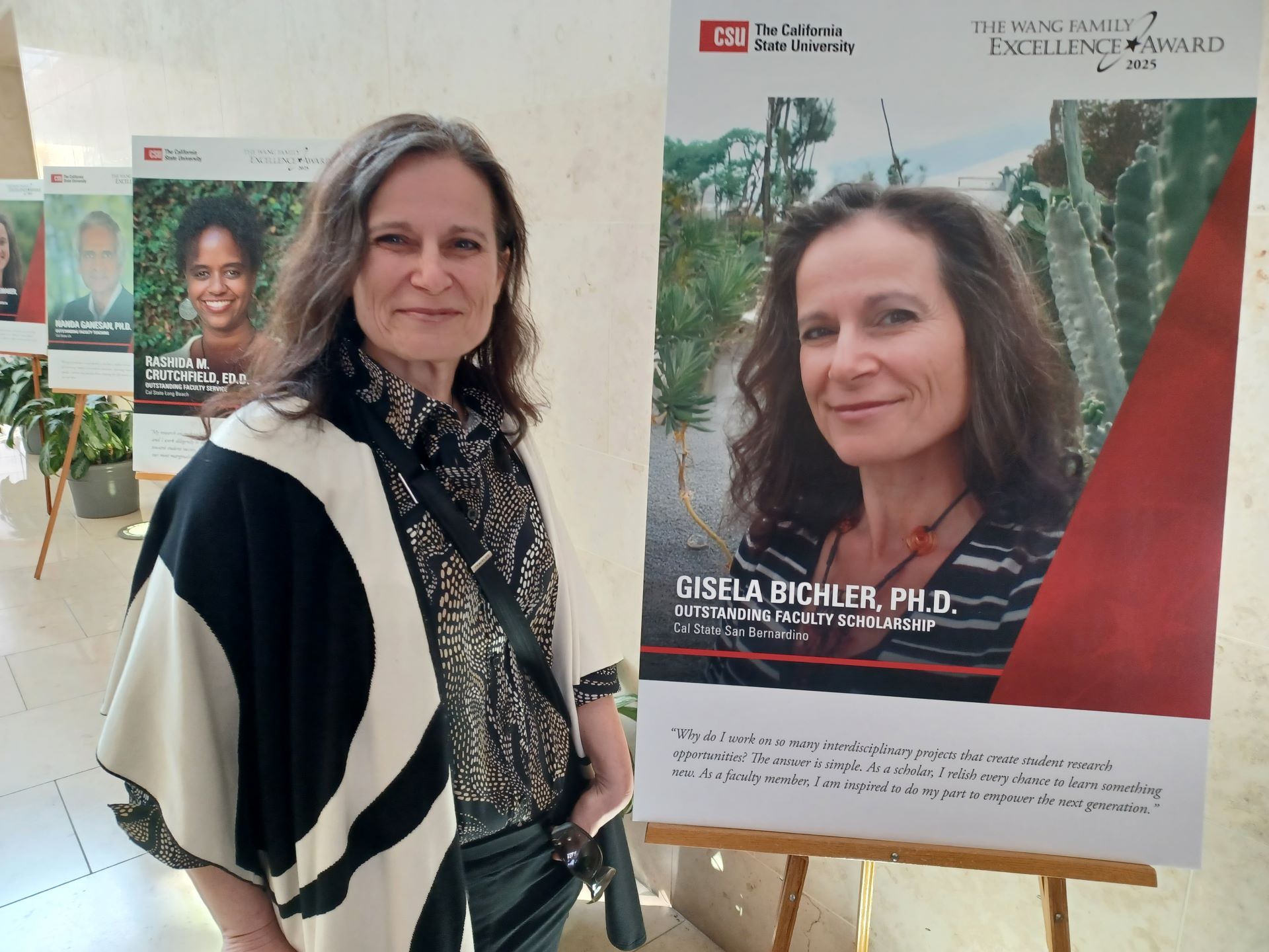 Gisela Bichler standing next to her award