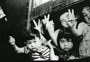 Japanese American children waving from train windows